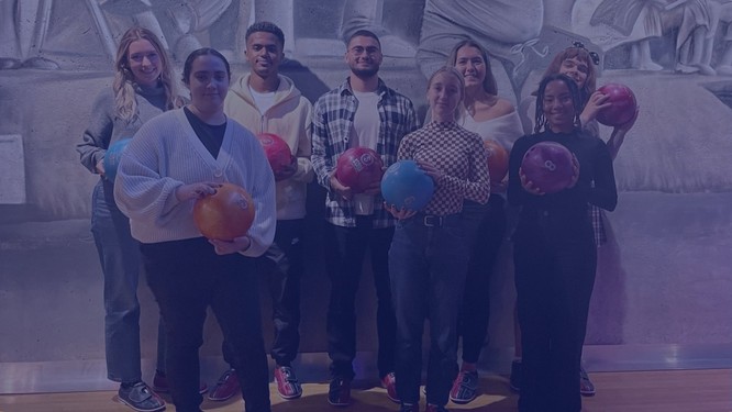 Eine Gruppe junger Menschen mit Bowlingkugeln auf einer Bowlingbahn, Foto mit blauem Overlay
