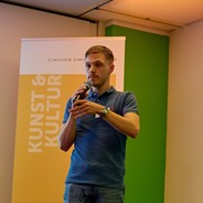 Timon Kollhoff auf einer Bühne mit Mikro